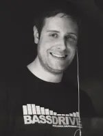 Chris Sabian smiling in a Bassdrive T-shirt, in black and white