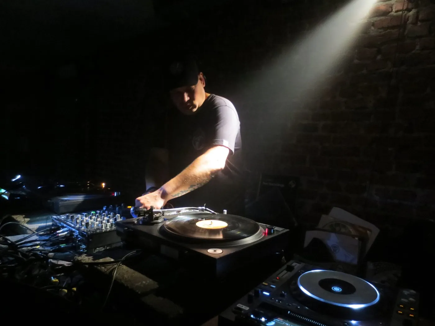 cYpher at the turntables in a beam of light
